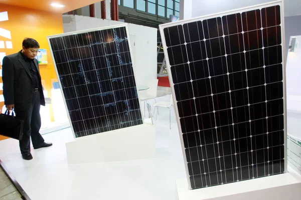 訪問者は 2011上海太陽光発電会議中にソーラーパネルを見て 中国の上海で 展示会 月2011 — ストック写真