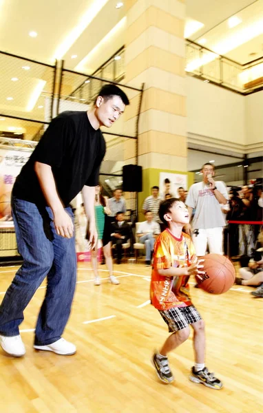 中国のバスケット_ボール選手のヤオミンはスラム 2010 日台北 八尾財団チャリティー ツアーのキャンペーンの間に彼を助けるように台湾子供を持ち上げ します — ストック写真