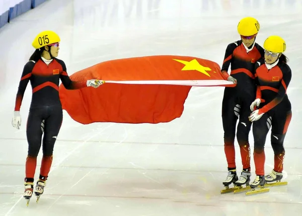 2011年12月10日 在中国上海举行的伊苏世界杯短道速滑比赛中 中国滑冰运动员在女子3000米接力决赛中夺冠后 用国旗庆祝 — 图库照片