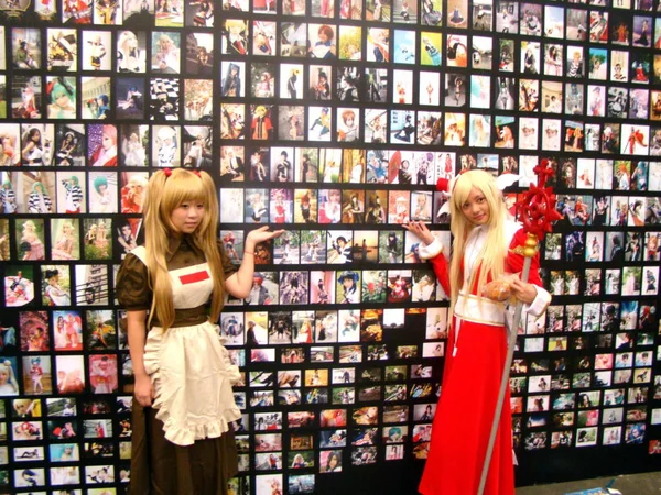 2010年7月29日 上海で開催された第8回中国デジタル エンターテインメント エキスポ カンファレンス チャイナジョイ2010 コスプレ衣装を着た2人の中国人ショーガールがコスプレ写真の壁の前でポーズをとる — ストック写真