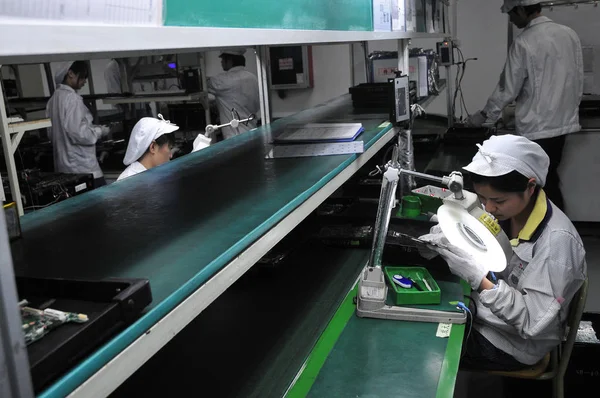 中国のFoxconn労働者は 深セン市のフォックスコン技術グループの深セン工場でのワークショップで集積回路基板をチェックします 中国南部広東省 2010 — ストック写真