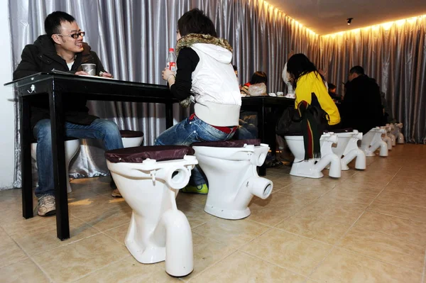화장실에 앉아있는 중국인 고객은 화장실을 테마로 레스토랑에서 먹는다 후베이 2010 — 스톡 사진