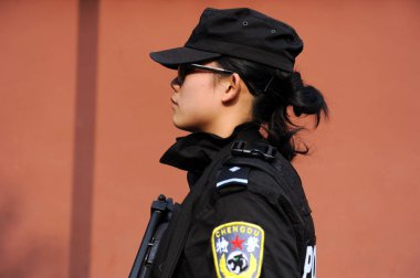 A Chinese special policewoman patrols a street in Chengdu city, southwest Chinas Sichuan province, 23 November 2011 clipart