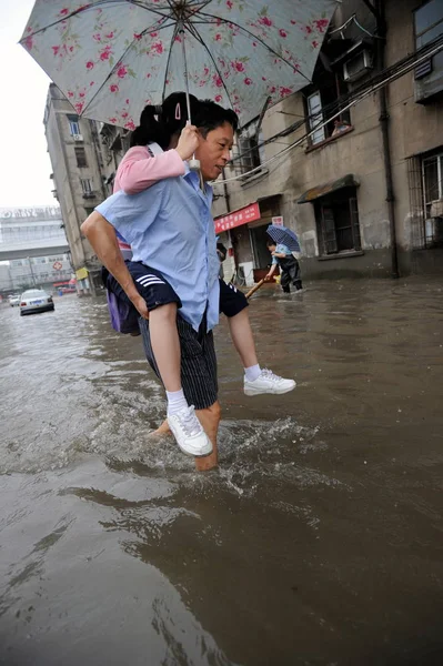 2010年7月11日 中国中部湖北省武汉市 一名携带女儿的中国男子在大雨中穿过洪水 — 图库照片