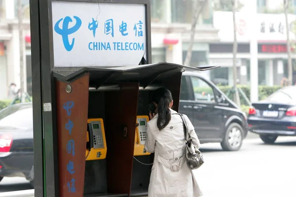 2010년 18일 상하이의 차이나 텔레콤 전화소에서 여성이 전화를 사용하고 — 스톡 사진