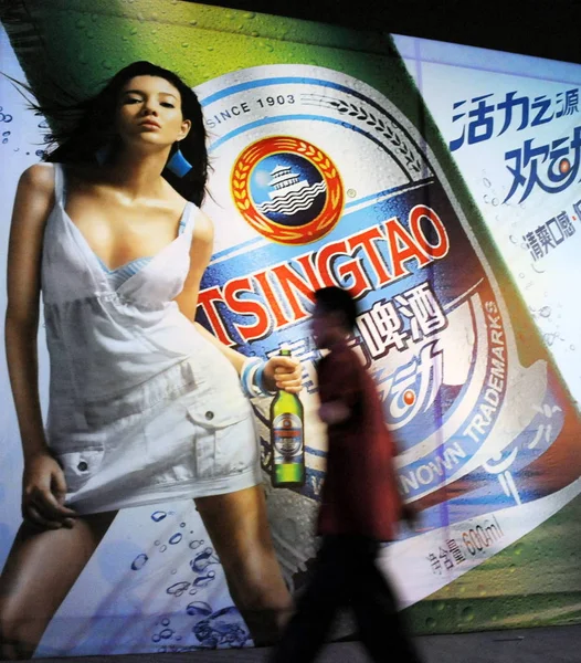 Een Chinese Man Loopt Langs Een Advertentie Van Tsingtao Bier — Stockfoto