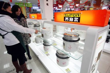 A Chinese employee helps a customer to shop for Supor rice cookers at a home appliance  store in Nantong city, east Chinas Jiangsu province, 22 February 2011 clipart