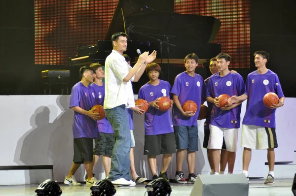 中国のバスケット ボール選手 ヒューストン ロケッツの姚明の前に立つ若いバスケット ボール選手博覧会喜び星公益まつり 上海での万博公園で万博文化センターで 2010 年の世界博覧会を推進 — ストック写真