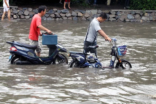 オートバイを持っている地元住民は 中国北東洪水の瀋陽の地を歩き 7月21日2010 — ストック写真