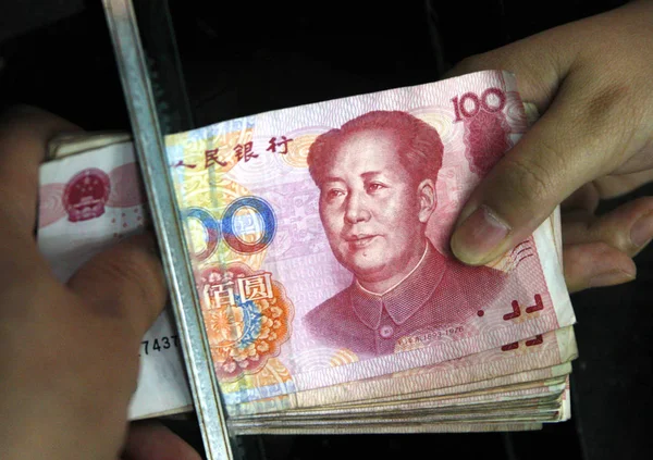 店員は 2011年12月7日 中国東部安寧省華北市の銀行で顧客に人民元 人民元 の人民元紙幣を渡す — ストック写真