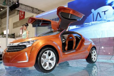 A model poses next to the IAT Cross Wind II EV Concept at the 11th Beijing International Automotive Exhibition, known as Auto China 2010, in Beijing, China, 26 April 2010. clipart