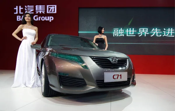 stock image Models pose by a C71 of Beijing Automotive during the 11th Beijing International Automotive Exhibition, known as Auto China 2010, in Beijing, China, April 23, 2010