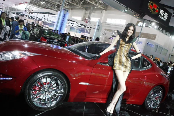 2010年4月23日 在中国北京举行的第十一届北京国际汽车展览会上 一个模型在吉利 Emgrand 旁边摆姿势 该展览会被称为2010年中国汽车展览会 — 图库照片