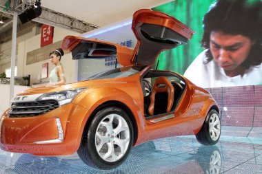 A model poses next to the IAT Cross Wind II EV Concept at the 11th Beijing International Automotive Exhibition, known as Auto China 2010, in Beijing, China, 26 April 2010. clipart