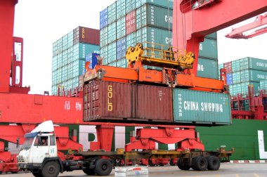 Containers are seen hoisted by a crane at the Lianyungang port in Lianyungang, east Chinas Jiangsu province, April 14, 2010 clipart