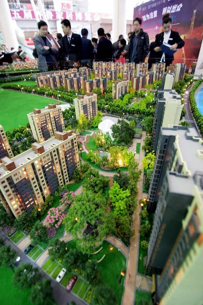 2010年4月16日 在中国东部山东省济南举行的房地产博览会上 中国购房者查看公寓楼的模型 — 图库照片