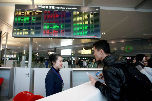 2010년 16일 상하이 홍차오 국제공항 제2터미널의 직원에게 문의하는 — 스톡 사진