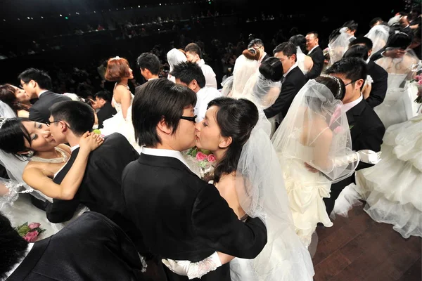 中国のカップル新婚キス中に 2010 上海の世界博覧会サイトの万博文化センターでフランス パビリオン主催集団結婚式 — ストック写真