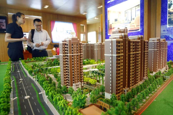 2010年7月16日 中国上海房地产交易会期间 一位中国女售货员向购房者介绍一个住宅项目 — 图库照片