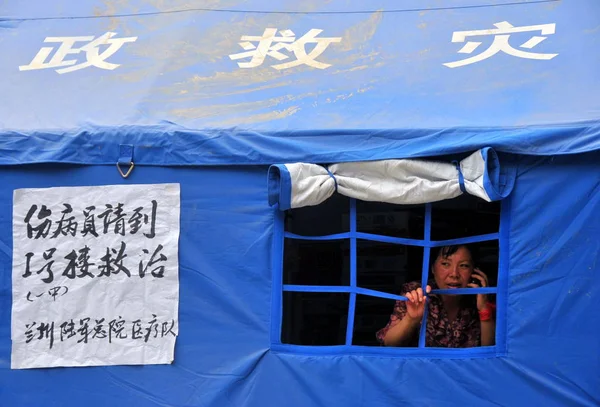 Китаянка Пользуется Мобильным Телефоном Спасательной Палатке После Разрушительного Оползня Округе — стоковое фото