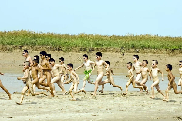 Chinese boys run naked on the bank of the Yellow River in Zhengzhou city, c...