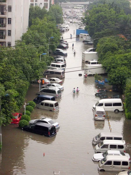 地元の中国人住民は 広州市 中国南部広東省の暴風雨の後 浸水した通りで車を通り過ぎる 2010年5月7日 — ストック写真