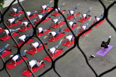 27 Chinese inmates and a yoga teacher perform yoga at a prison in Chengdu city, southwest Chinas Sichuan province, 18 June 2010 clipart
