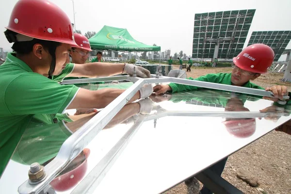 Chinese workers install solar panels at the Badaling Platform of Solar Thermal Power in Yanqing District, Beijing, China, June 30, 2010