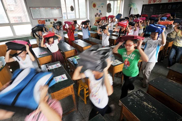 Chińskich Uczniów Posiadających Torby Szkolne Nad Głową Ewakuować Klasy Celu — Zdjęcie stockowe