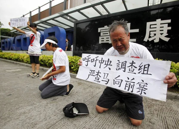 Parents and elder sister of Foxconn employee Ma Xiangqian who committed suicide by jumping off a building, show the photo of Ma Xiangqian and signs saying We Appeal To the Investigation Team from the Central Government to Thoroughly Investigate the C — Stock Image Parents Elder Sister Foxconn Employee Xiangqian Who Committed Suicide Jumping Stock Photo