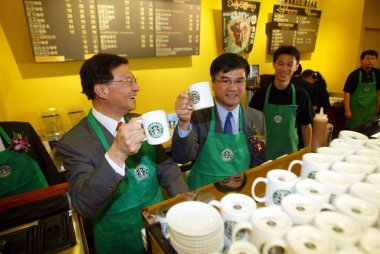 --FILE--Gary Faye Locke, second left, then Governor of Washington, cheers in a Starbucks Coffee cafe in Beijing, China, 14 October 2003. clipart