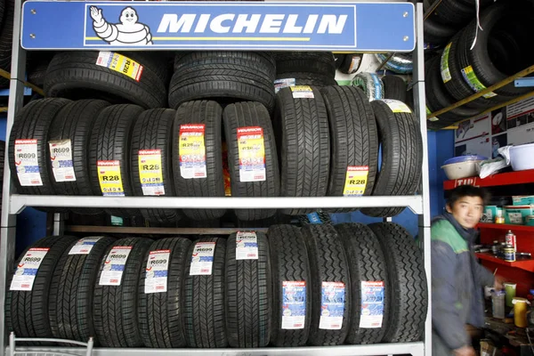 File Čínský Opravák Stojí Vedle Pneumatik Polici Logem Michelin Garáži — Stock fotografie