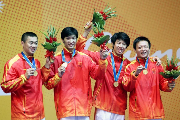 2010年11月23日 在广东省广州市举行的第十六届亚运会男子团体击剑比赛中 中国队的雷声 黄良才 朱军和张连良在领奖台上庆祝 — 图库照片
