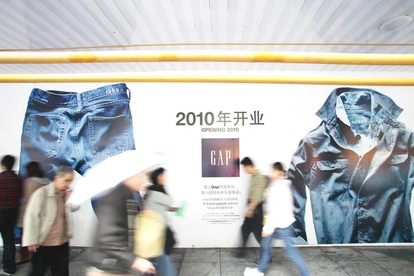 2010년 10월 24일 상하이에서 주민들이 Gap 광고를 지나걷고 — 스톡 사진