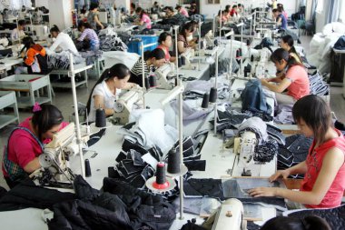 Chinese factory workers manufacture garments to be exported at a factory in Haian county, east Chinas Jiangsu province, 1 September 2008 clipart