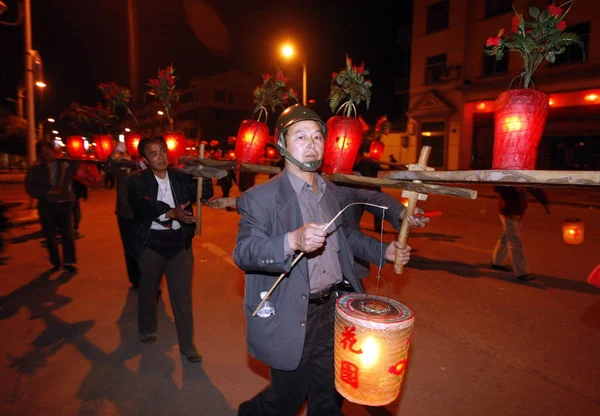 地元の中国人村人は 2009年2月12日木曜日 東陽市東陽市の華陽村でスツールドラゴンダンスを行うためにランタンで飾られた木製のスツールを肩に担い 2009年2月12日 — ストック写真