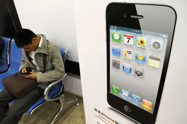 Chiński Człowiek Używa Swojego Telefonu Komórkowego Obok Plakat Reklamowy Dla — Zdjęcie stockowe