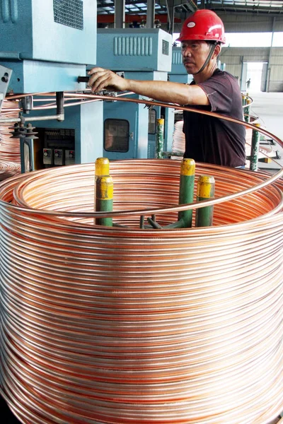 2010年8月7日 中国江苏省南通市铜制品厂的一名中国工厂工人生产卷铜管 — 图库照片