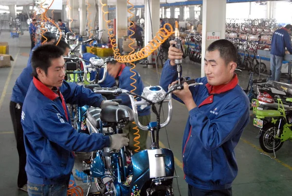 中国の工場の労働者は Xinchang 電気機器製造株式会社の工場で韓国に輸出される電動自転車を組み立てる 東中国山東省 Weifang 月2008 — ストック写真