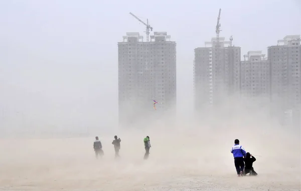 中国の子供たちは 2009年2月18日水曜日 中国北西部甘粛省蘭州市の建設現場で砂嵐の中で凧を飛ばします — ストック写真