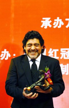 Former Argentine player and coach Diego Maradona holds a statuette at a press conference in Beijing, China, 4 November 2010 clipart