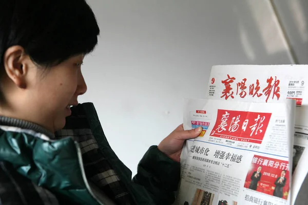 2010年12月9日 一名中国妇女在中国中部湖北省向阳市的办公室看报纸 — 图库照片