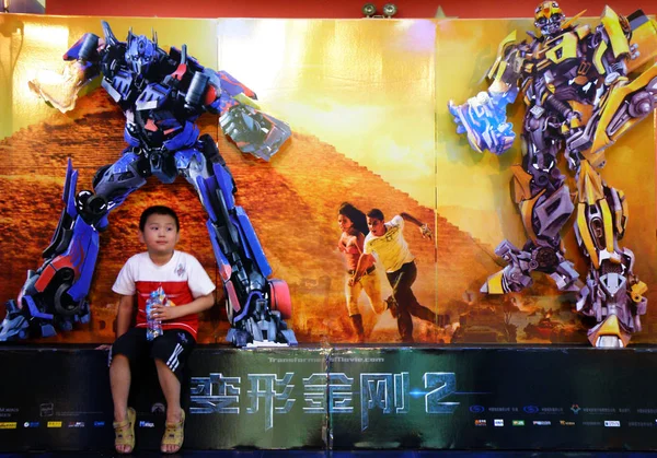 2009年6月23日 在中国中部湖北省宜昌的一家剧院里 一个中国孩子坐在电影 变形金刚2 的广告前 — 图库照片