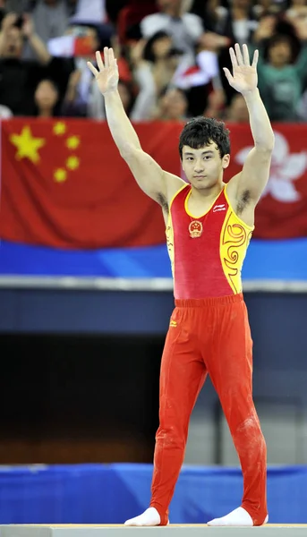 2010年11月17日 在中国南方广东省广州市举行的第16届亚运会上 中国的冯哲在男子双杠决赛中庆祝 — 图库照片