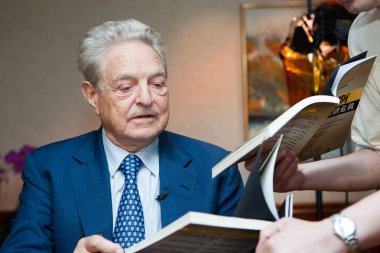 Financier George Soros, Chairman of the Soros Fund Management and Open Society, signs for a reader during an interview in Shanghai, China, Friday, June 5, 2009 clipart