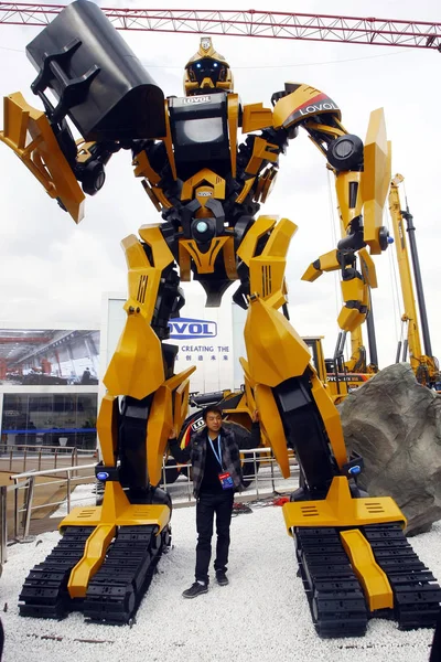 在2010年工程机械 建材机械 建筑车辆和设备国际贸易展览会上 一位中国人站在一个巨大的机器人下 被称为 宝马中国2010 在上海新国际博览中心举行 — 图库照片