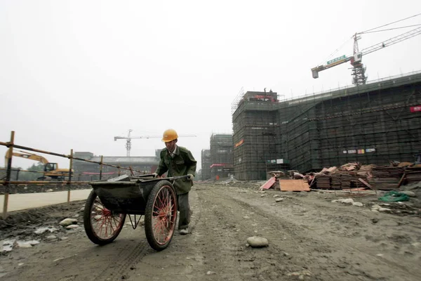 中国の建設労働者は 2009年4月29日 中国四川省南西部の成都市の5月12日の地震で破壊された十元中学校を再建する姿が見られる — ストック写真