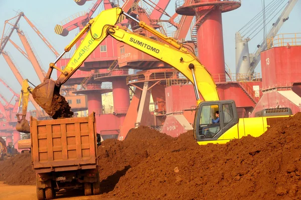 掘削機は 2010年10月31日 中国東部江蘇省梁雲江市の梁雲江港でレアアースを積み込むトラックを積み込む — ストック写真