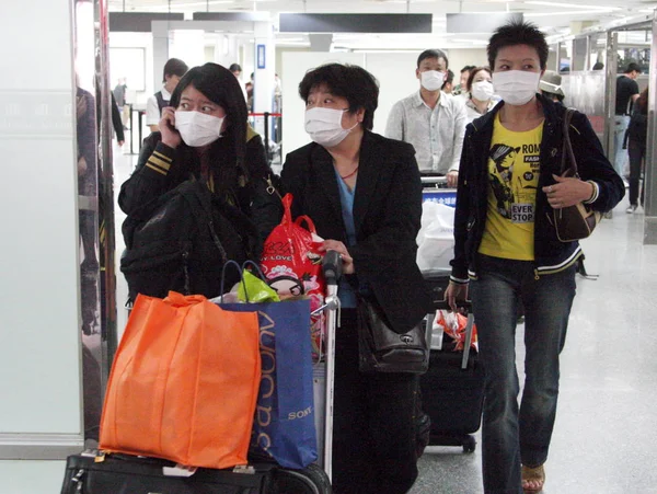 H1N1 インフルエンザ予防マスクを身に着けている日本からの乗客は水曜日 2009 上海の上海虹橋国際空港に到着します — ストック写真