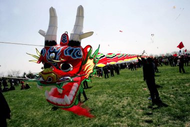 Chinese contestants try to fly a dragon-shaped kite during the 26th Weifang International Kite Festival, in Weifang, east Chinas Shandong province, April 21, 2009 clipart